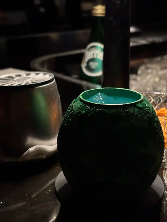 A close-up of a bar counter taken at Darkside, Hong Kong, featuring two cups of Hong Kong-themed cocktails.